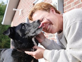 Marcia Ranger gets kisses from her dog Ebony at their south-end home in Sudbury on Tuesday. Ranger, Ebony and a friend had an encounter with a bear on Monday around 6 p.m., with both women being injured. The wound on Ranger's face required 20 stitches. (Gino Donato/Sudbury Star)