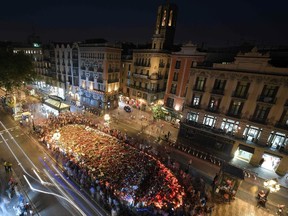 A general view taken on the Rambla boulevard in Barcelona on August 26, 2017 shows people gathering around a flower tibute for the victims of last week's deadly attacks during a march against terrorism which slogan is #NoTincPor (I'm Not Afraid). Tens of thousands of Spaniards and foreigners stagged a defiant march against terror through Barcelona following last week's deadly vehicle rampages. The Mediterranean city is in mourning after a van ploughed into crowds on Las Ramblas boulevard on August 17, followed hours later by a car attack in the seaside town of Cambrils. / AFP PHOTO / LLUIS GENELLUIS GENE/AFP/Getty Images