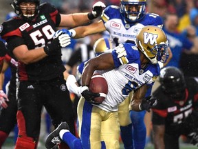 Winnipeg Blue Bombers' Chris Randle (8) makes his way past Ottawa Redblacks' Jake Silas (59) to score a touchdown during first half of a CFL football game in Ottawa on Friday, Aug. 4, 2017. THE CANADIAN PRESS/Justin Tang