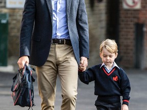 Britain's Prince William, left, holds Prince George's hand as he arrives for his first day of school at Thomas's school in Battersea, London, Thursday, Sept. 7, 2017. Prince William's pregnant wife Kate was too ill with morning sickness Thursday to take young Prince George to his first day of school. (Richard Pohle/Pool Photo via AP)