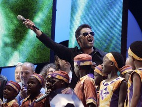 In this Saturday, July 2, 2005 file photo, British singer George Michael accompanied by other musicians and children from Africa gestures to the crowds during the Live 8 concert in Hyde Park, London. A new single by George Michael has been released, eight month after the music star's death. "Fantasy," first recorded in the late 1980s, has been reworked by funk-master Nile Rodgers and received its first radio airplay on Thursday, Sept. 7, 2017. Rodgers tweeted that he felt "emotional ambiguity" about the song, which evoked "tears, uncertainty, happiness and love." (AP Photo/Lefteris Pitarakis, File)