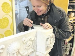 Interior designer Heidi Pribell removes the 1805 marble mantlepiece from the wall of a home in Boston. Pribell later sold the mantlepiece to the Museum of Fine Arts. (Rhea Nawar/Heidi Pribell/via AP)