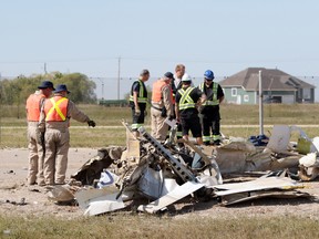 Workers with the Transportation Safety Board of Canada look at the debris from the wreckage of a Beech one-engine model A23-19 aircraft is scene on Aviation Boulevard located on the west side of St. Andrews Airport in the RM of St. Andrews, which is located just north of Winnipeg, Man. RCMP responded to the crash shortly after 4:30 a.m. on Thursday, September 7, 2017. A 29-year-old male from Thunder Bay, Ontario died in the crash. (Brook Jones/Selkirk Journal/Postmedia Network)