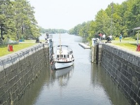 A boater enters the Burritts Rapids Lock on the Rideau Canal as others manually operate the lock gates. (Postmedia file photo)