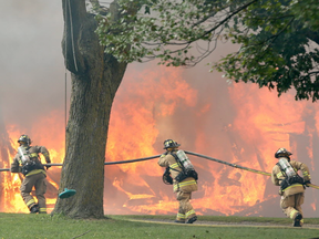 The 2600 block of Prince of Wales was blocked off to traffic Friday afternoon after a fire broke out in a barn on a farming property. Almost a dozen fire trucks were on scene to battle the blaze. (Julie Oliver, Postmedia)