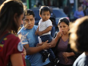 Bystanders watch as immigrants' rights demonstrators march in protest of President Trump's decision on DACA on September 7, 2017 in the Queens borough of New York City.  (Photo by John Moore/Getty Images)