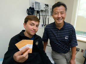 Colin Labrie, 12, of Kitchener, holds envelopes containing a small amount of peanut flour mixed with oat flour at St. Joseph?s Hospital in London with Dr. Harold Kim. Labrie is taking part in a program at the hospital where patients who are allergic to peanuts consume a small amount of peanut flour every day to build up immunity. (MORRIS LAMONT, The London Free Press)