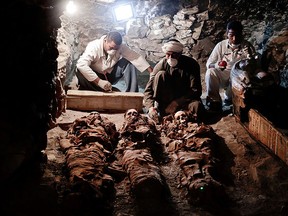 Archaeologists work on mummies found in the New Kingdom tomb that belongs to a royal goldsmith in a burial shaft, in Luxor, Egypt, Saturday, Sept. 9, 2017. (AP Photo/Nariman El-Mofty)