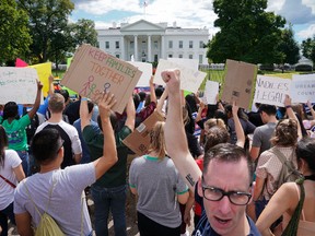 Malcolm McCluskey, right, pumps his fist in the air as he joins in a chant with supporters of Deferred Action for Childhood Arrival program (DACA) during a demonstration on Pennsylvania Avenue in front of the White House in Washington, Saturday, Sept. 9, 2017. President Donald Trump ordered and end of protections for young immigrants who were brought into the country illegally as children, but gave Congress six months to act on it. (AP Photo/Pablo Martinez Monsivais)