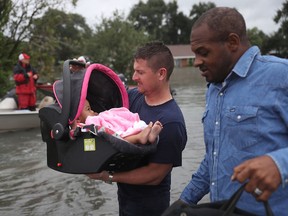 A rescue worker carries a baby to dry land after she was rescued from the flooding of Hurricane Harvey on August 30, 2017 in Port Arthur, Texas. (Photo by Joe Raedle/Getty Images)