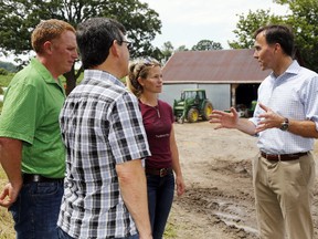 Federal finance minister Bill Morneau, right, discusses farming with Enright Cattle Co. owners Darold (left) and Kara Enright and Hastings-Lennox and Addington MP Mike Bossio Wednesday, July 19, 2017 at the farm southwest of Tweed, Ont. (Luke Hendry/Belleville Intelligencer/Postmedia Network)
