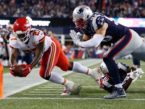 Chiefs running back Kareem Hunt (left) crosses the goal line to score a touchdown past Patriots safety Duron Harmon (bottom right) and linebacker Kyle Van Noy (top right) during NFL action in Foxborough, Mass., on Thursday, Sept. 7, 2017. (Michael Dwyer/AP Photo)