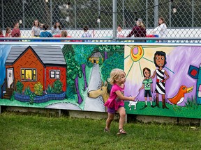 Cecilia Berg, 2, looks at the new mural on the Ellingson Park community rink, 6510 111 St., in Edmonton Saturday Sept. 9, 2017. Parkallen Community League wrapped the community ice rink in a large mural to help prevent graffiti. Photo by David Bloom