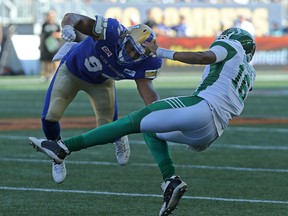 Blue Bombers' Jackson Jeffcoat (left) sends Roughriders quarterback Brandon Bridge flying during the Banjo Bowl in Winnipeg on Saturday, Sept. 9, 2017. (Kevin King/Winnipeg Sun)