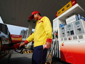 In this Nov. 5, 2013 photo, a worker fills a car up with gas at the state-owned PetroChina gas station in Shanghai, China. (AP Photo)