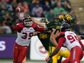 Edmonton Eskimos Mike Reilly (13) manages to get a pass away against the Calgary Stampeders on Saturday September 9, 2017 in Edmonton.