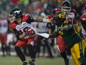 Edmonton Eskimos Almondo Sewell (90) reaches for Calgary Stampeders quarterback Bo Levi Mitchell (19) on Saturday September 9, 2017 in Edmonton.