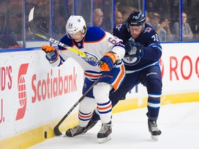 Edmonton Oilers Steven Owre (left) battles with Winnipeg Jets Leon Gawanke behind the net during NHL preseason hockey action at the Young Stars Classic held at the South Okanagan Events Centre in Penticton, BC, September, 9, 2017.