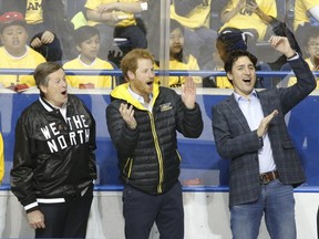 Toronto Mayor John Tory, Prince Harry and Prime Minister Justin Trudeau are pictured in May, 2017, as they celebrate a goal at a demonstration game at Ryerson University of sledge hockey which will be a sport in the 2017 Invictus Games. (MICHAEL PEAKE, Toronto Sun)
