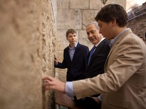 In this Jan. 22, 2013 file photo, Israeli Prime Minister Benjamin Netanyahu, centre, prays with his sons Yair, background, and Avner, right, at the Western Wall. (AP Photo/Uriel Sinai, Pool, File)