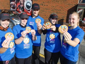 Tim Hortons staff at the Arlington Park Place location, along with Maclaine Chadwick from the University Hospitals Kingston Foundation, far right, stand outside the store on Saturday showing off a batch of practice Smile cookies they've been working on in preparation for the $1 Smile Cookie campaign, Sept. 11-17. (Julia McKay/The Whig-Standard)