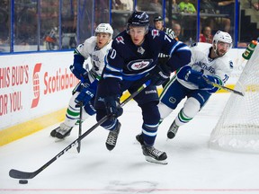 Winnipeg Jets’ Leon Gawanke (middle) skates away from Canucks players at the Young Stars Classic in Penticton, B.C. (Richard Lam/Postmedia Network)