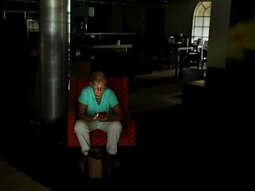 A hotel guest looks at her mobile phone as the power remains off at the Courtyard by Marriott one day after Hurricane Irma struck the state September 11, 2017 in Fort Lauderdale, Florida. (Chip Somodevilla/Getty Images)