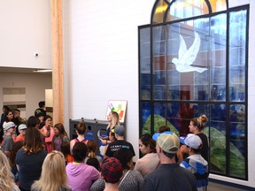 A tour group is shown a stained glass at the new École St. Joseph School on Sept. 5. The window is originally from their old library (Peter Shokeir | Whitecourt Star).