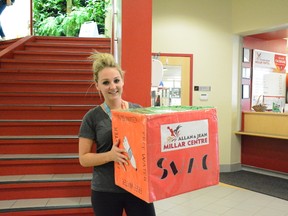 Fitness attendant Melanna Swant holds a dice that members can role to win prizes on Sept. 6 (Peter Shokeir | Whitecourt Star).