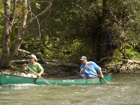 John Hlodan, left, and son Ryan paddle the Thames River just below the broken Springbank Dam Monday. A local angler?s recent catch of a muskie in the river has renewed questions about the value or repairing the dam. (MIKE HENSEN, The London Free Press)
