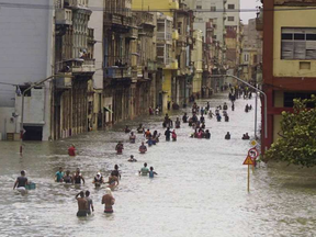 People move through flooded streets in Havana after the passage of Hurricane Irma, in Cuba, Sunday, Sept. 10, 2017. RAMON ESPINOSA / AP