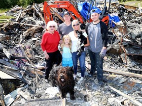 Dan and Leeanne Smith are seen with their daughter Emma, 8, son Josh, 19, Leeanne's mother, Pheme Bennett, and the two dogs that survived the fire, Darby, lower left, and Morgan. (Ian MacAlpine/The Whig-Standard)