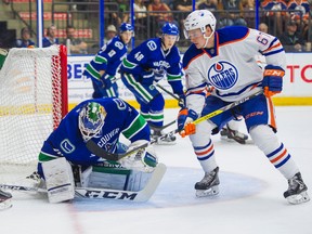 Vancouver Canucks goalie Michael Garteig (left) covers up the puck before Edmonton Oilers' Austin Glover can get a stick on it during NHL preseason hockey action at the Young Stars Classic held at the South Okanagan Events Centre in Penticton, B.C., September 11, 2017.