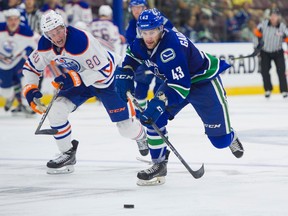 Vancouver Canucks Jonah Gadjovich gives chase to the loose puck while pressured by Edmonton Oilers Austin Strand during NHL preseason hockey action at the Young Stars Classic held at the South Okanagan Events Centre in Penticton, BC, September, 11, 2017.