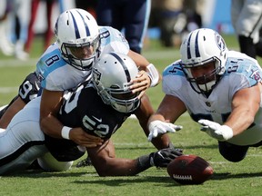 Tennessee Titans offensive guard Josh Kline recovers a fumble by quarterback Marcus Mariota as Oakland Raiders defensive end Khalil Mack also scrambles for the ball in the second half of an NFL game on Sept. 10, 2017. (AP Photo/James Kenney)