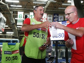 Michael Cullen, executive director of United Way Centraide North East Ontario, and volunteer Chris Peters demonstrate the new modernized 50/50 draw program the will be used at Sudbury Wolves home games at a press conference in Sudbury, Ont. on Monday September 11, 2017.