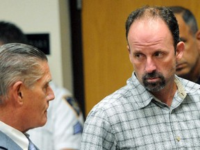 In this July 31, 2014 file photo, John Bittrolff, right, listens to his attorney, William Keahon, during his arraignment on murder charges in Riverhead, N.Y. (James Carbone/Newsday via AP, Pool, File)
