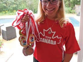14-year-old Charlotte Bolton with her 17 team and individual medals from the 2017 World Dwarf Games in Guelph.