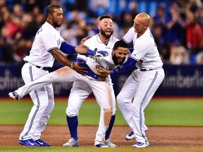 Toronto Blue Jays shortstop Richard Urena is mobbed by teammates after hitting a game-winning RBI single against the Baltimore Orioles during MLB action in Toronto on Sept. 12, 2017. (THE CANADIAN PRESS/Frank Gunn)