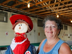 Yvonne Compton, Kingston and District Agricultural Society board president, poses for a photo with the first scarecrow to arrive  in Kingston on Wednesday as part of the board scarecrow contest, just one of the things to take in at the 187th Kingston Fall Fair taking place at the Memorial Centre this weekend. (Julia McKay/The Whig-Standard)