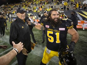 Hamilton Tiger-Cats head coach June Jones is congratulated by offensive lineman Mike Filer at the conclusion of a win over the Toronto Argonauts in Hamilton, Ont., on Sept. 4, 2017. (THE CANADIAN PRESS/Peter Power)