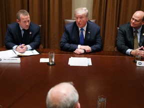Rep. Josh Gottheimer, D-N.J., left, and Rep. Tom Reed, R-N.Y., right, listen as President Donald Trump speaks during a meeting with a bipartisan group of lawmakers in the Cabinet Room of the White House in Washington on Wednesday, Sept. 13, 2017. (Evan Vucci/AP Photo)