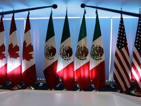 National flags representing Canada, Mexico, and the U.S. are lit by stage lights at the North American Free Trade Agreement, NAFTA, renegotiations, in Mexico City, Tuesday, Sept. 5, 2017. THE CANADIAN PRESS/AP/Marco Ugarte