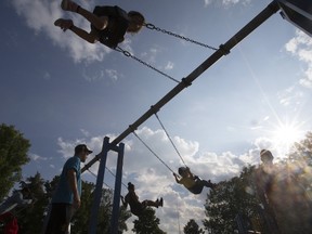 Kids play on the swings at Natal Park in Scarborough on Aug. 8, 2017. (STAN BEHAL/TORONTO SUN)