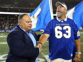 Former Winnipeg Blue Bomber Chris Walby, right, shakes hands with Bomber president Wade Miller during halftime at Investors Group Field Winnipeg on June 24, 2016. (Kevin King/Winnipeg Sun/Postmedia Network)