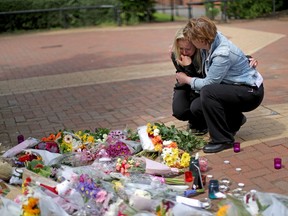 People react as they lay lowers in the centre of the Lancashire village of Tarleton, the home village of Georgina Callander, 18, and Saffie Rose Roussos, 8, who killed in the Manchester attack on May 22, 2017. (GETTY IMAGES/PHOTO)