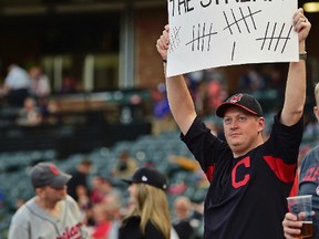 Cleveland Indians fan Matthew Van Worner holds a sign before a baseball game between the Cleveland Indians and Kansas City Royals on Sept. 14, 2017, in Cleveland. (AP Photo/David Dermer)