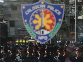 New police trainees are reflected on glass at the Caloocan City Police Station in metropolitan Manila, Philippines on Friday, Sept. 15, 2017. (AP Photo/Aaron Favila)