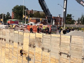 Firefighters life a civtim on a stretcher out of a 75-foot deep construction siute on King Edward Friday. The worker suffered a back injury and was in stable condition at the scene.