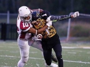 Liam Cousineau of the St. Charles Cardinals hauls down  Charlie Dow of the Lively Hawks during senior boys high school football opening season action in Sudbury, Ont. on Thursday, September 14, 2017. St. Charles won 21-14. Gino Donato/Sudbury Star/Postmedia Network